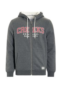 Sudadera con cremallera gris fabricada en un material suave. Cuenta con un logo impreso en blanco y rojo, cordones en la capucha y bolsillos frontales.