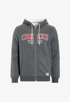 Sudadera gris con cremallera y cordones, texto "CREEKS ORIGINAL" en blanco y rojo, bolsillos tipo canguro y puños acanalados. Tela suave de peso medio.