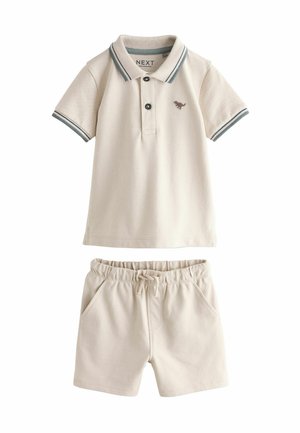Light beige polo shirt with grey-striped collar and small logo, paired with matching elastic waistband shorts featuring side pockets.