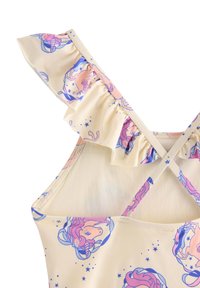 Żółty materiał stroju kąpielowego z różowym i niebieskim wzorem jednorożców, z falbanianymi ramiączkami i krzyżującym się tyłem. Miękka, gładka faktura.