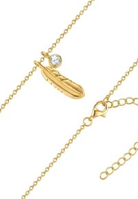 Zlati necklace s teksturirano obeskom v obliki peresa, ki ima majhen prozoren kristalni okras. Vključuje sponko v obliki jastreba in nastavljive verige.