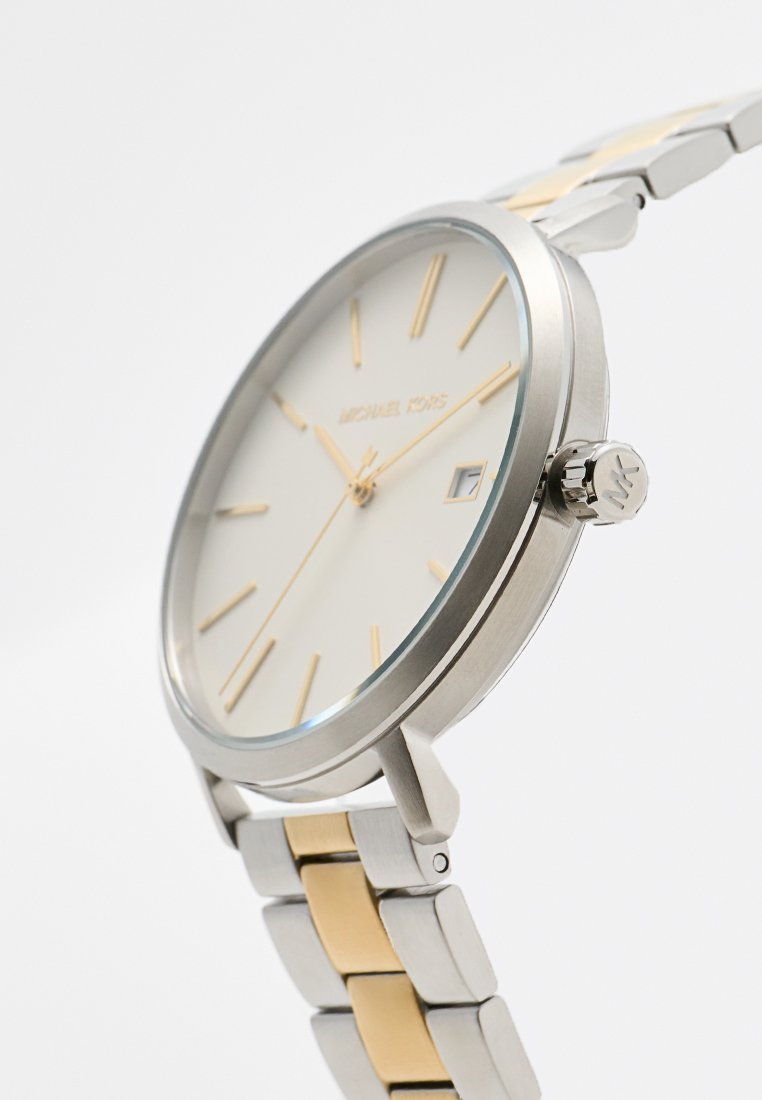 Montre-bracelet en argent et or avec un cadran blanc, index d'heure dorés, guichet de date à 3 heures et bracelet bicolore en acier inoxydable.