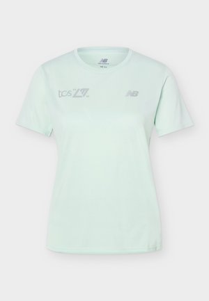 Ανοιχτό γαλάζιο αθλητικό μπλουζάκι με κοντά μανίκια, με τα λογότυπα New Balance και TCS στο στήθος, με στρογγυλή λαιμόκοψη και εφαρμοστή κοπή.