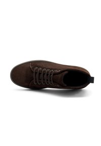 Sneaker alta in suede marrone con punta rotonda, suola in gomma nera e occhielli per i lacci. Presenta un passante sul retro per una facile calzata.
