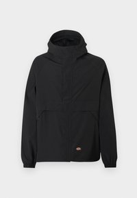 Μαύρο μπουφάν με κουκούλα και φερμουάρ μπροστά, ελαστικές μανσέτες, δύο πλαϊνές τσέπες με φερμουάρ και μικρό λογότυπο της μάρκας κοντά στο τελείωμα σε απλό φόντο.