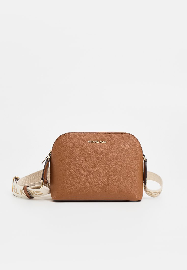 Sac à bandoulière en simili cuir marron avec une forme arrondie, des garnitures dorées et une sangle en tissu beige portant un texte de logo. Texture lisse.