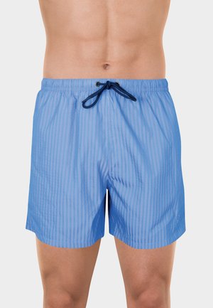 Short de bain bleu rayé avec une ceinture élastique et un cordon bleu foncé, porté par un homme torse nu sur fond blanc.