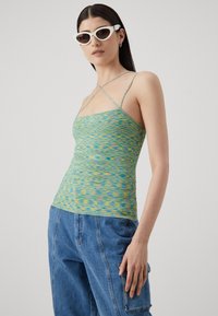 Knitted top in blue, green, and yellow with thin straps and a fitted shape, featuring a textured, wavy pattern.