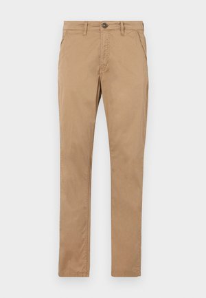 Brune, rette chinos laget av bomull. Har en frontknapp, glidelås og sidelommer med jevn tekstur og ingen synlige mønstre.