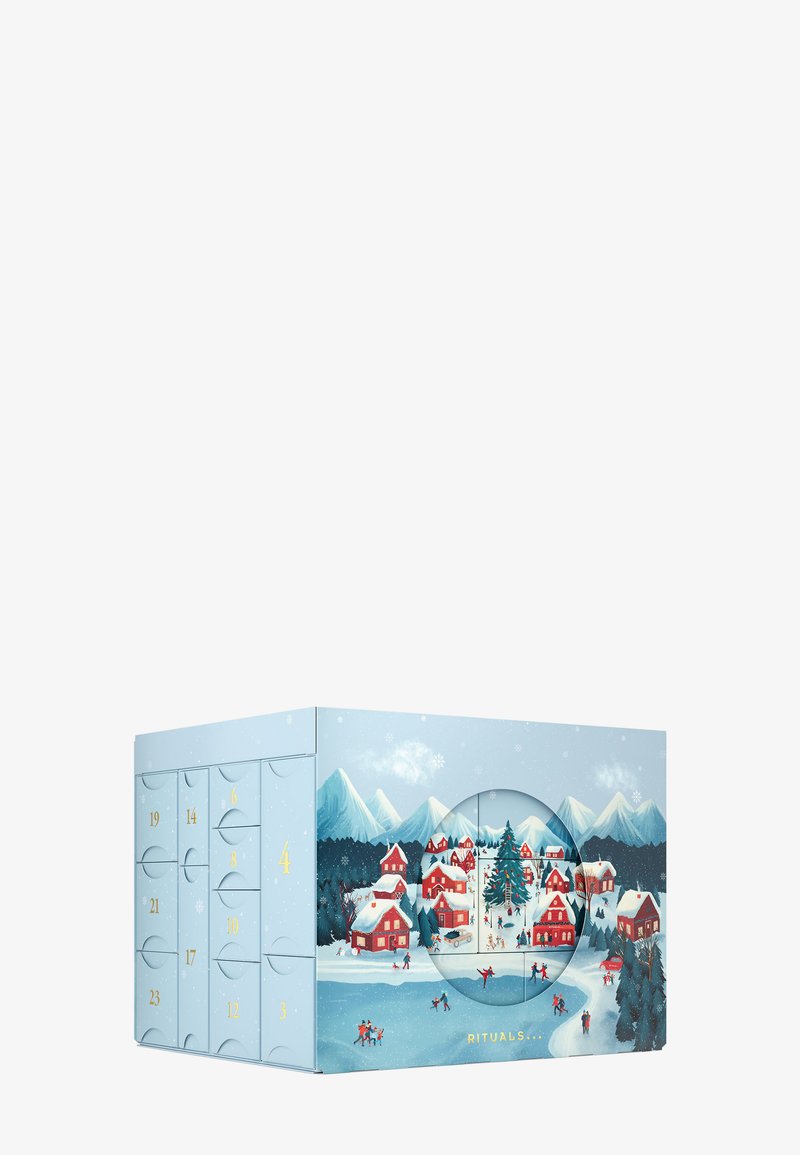Calendrier de l'Avent avec un extérieur bleu clair, présentant des maisons avec toits rouges et des montagnes enneigées. Comprend des portes numérotées à tirer et une découpe circulaire.