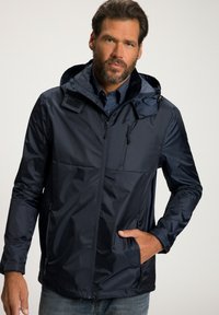 Navyblauer wasserdichter Jacke mit Kapuze, ausgestattet mit einem Reißverschluss an der Vorderseite, Seitentaschen und einer glatten Oberfläche. Inklusive Belüftung und verstellbaren Akzenten.