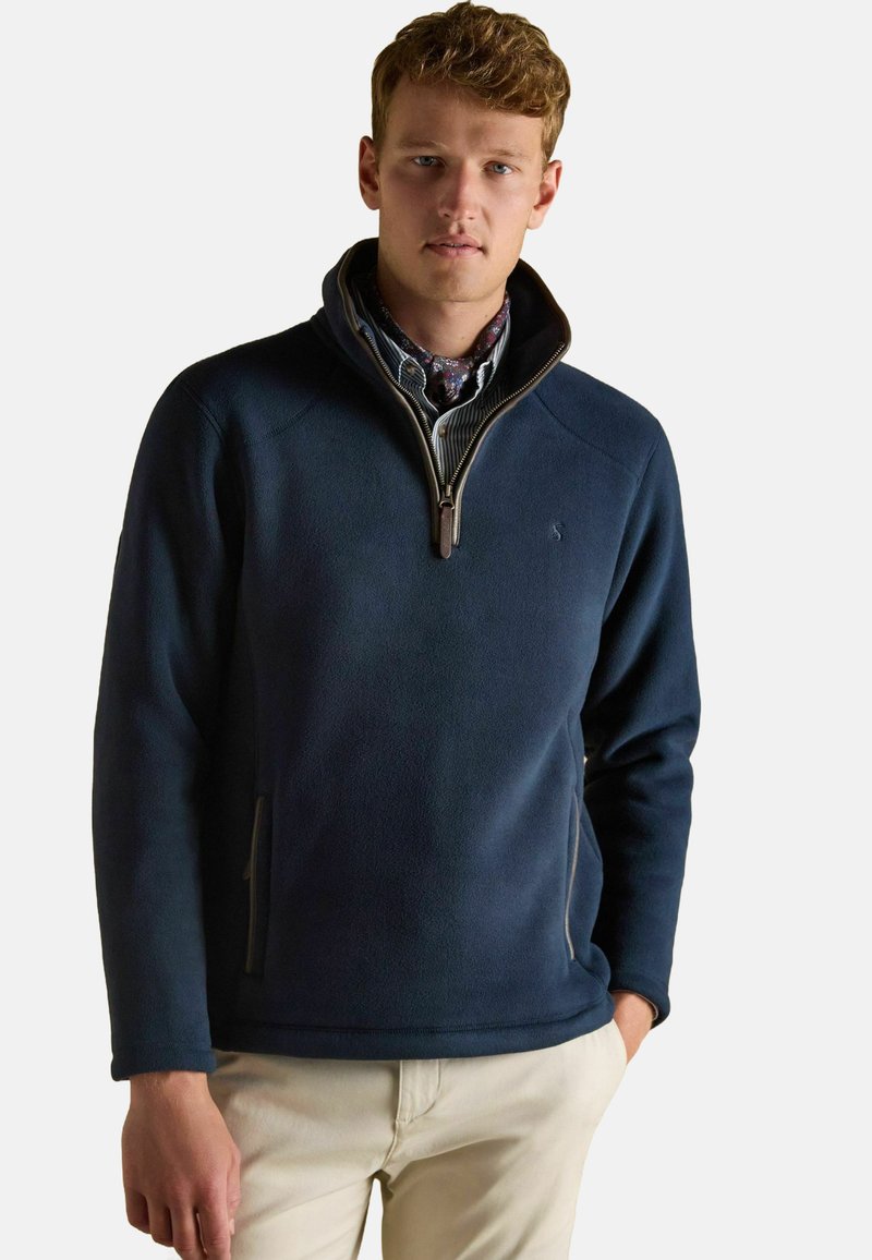 Námornícky fleecový pulóver s golierom na zips, s bočnými vreckami a hladkou textúrou. Dizajn obsahuje jemný logotyp na hrudi.