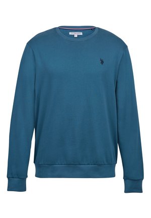 Teal dukserica dugih rukava od mekog materijala s rebrastim manžetama i rubom. Ima mali, tamni logo na grudima. Klasičan okrugli izrez.