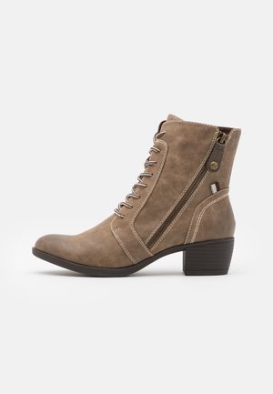 Bruine faux suede enkellaars met een ronde neus, vetersluiting aan de voorkant, zijrits en chunky blokhak. Contrasterende stikdetails zichtbaar.