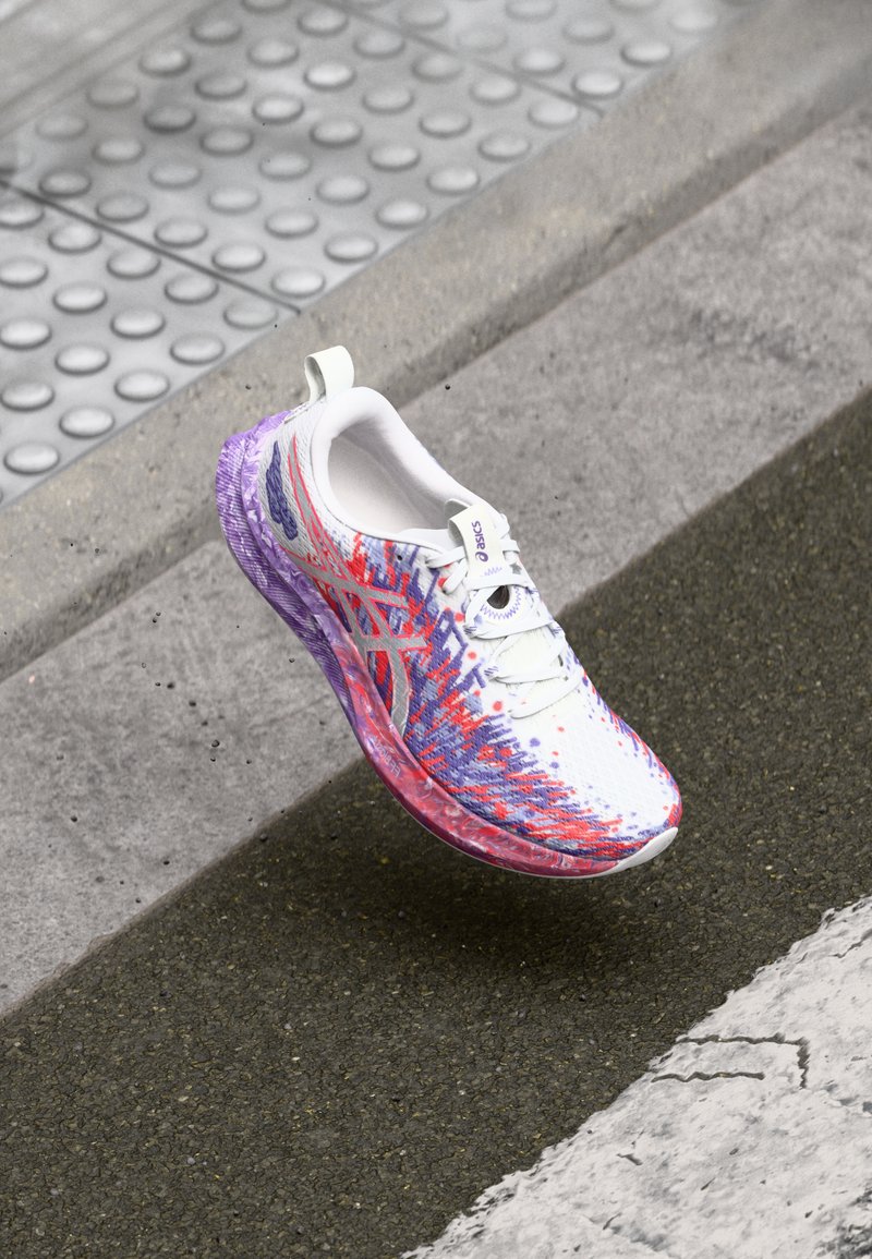 Lightweight running shoe with a white upper, purple and red graphic design, textured midsole, and a purple translucent outsole.