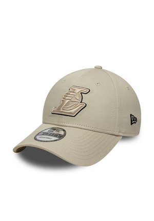 Beige adjustable baseball cap with embroidered stylized "L" logo on front and small black emblem on side.