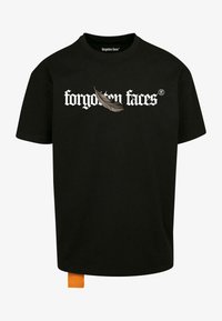 Camiseta de algodón negra con el texto "caras olvidadas" en una fuente gótica blanca, un gráfico de pluma y una etiqueta naranja en el dobladillo.