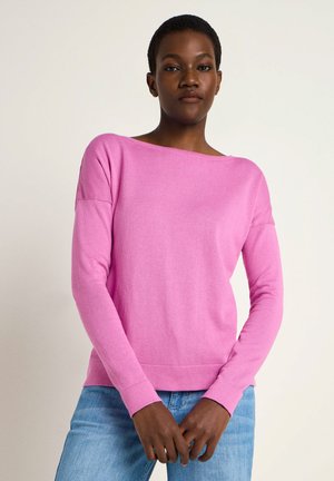 Rosa Strickpullover mit Rundhalsausschnitt und langen Ärmeln, mit einem gerippten Saum. Getragen mit hellblauen Jeans. Glatte Textur.