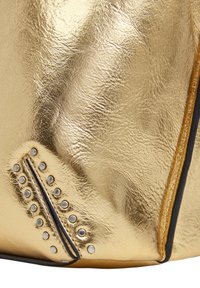 Sac à main en métal doré avec une surface texturée, détail de fermeture éclair et clous argentés sur un côté. Les accents comprennent une fermeture éclair noire contrastante.