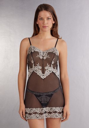 Svart spetsnattlinne med blommig vit spetsdetalj, transparent material, fitted form, justerbara spaghettistlajpar och matchande svart underkläder.