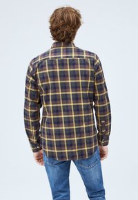 Camicia a quadri blu scuro e giallo, con maniche lunghe, colletto aperto e orlo curvo. Tessuto strutturato con vestibilità comoda.