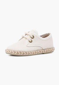 Scarpa in tela bianca con punta arrotondata, design con lacci e due occhielli metallici. Presenta una suola in juta intrecciata con una texture a treccia.