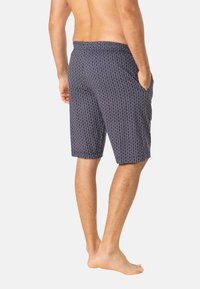 Shorts à motif bleu marine en tissu doux, avec poches latérales, coupe décontractée et longueur au genou ornée d'un design géométrique texturé.