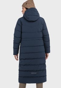 Navyblauer Puffer-Mantel mit Kapuze, der horizontale Steppnähte, eine leicht taillierte Taille und ein dezentes Logo-Patch am Saum aufweist.