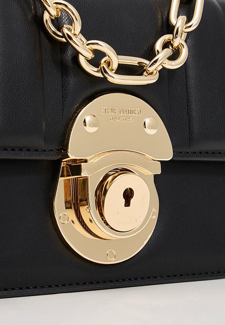 Schwarze synthetische Handtasche mit goldfarbener Schlossverschluss, einer miteinander verbundenen Kettenriemen und einem gesteppten Texturmuster auf dem Vorderpanel.
