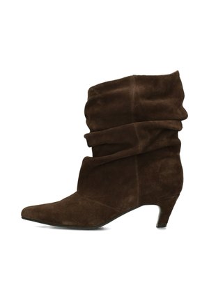 Botte mi-mollet en daim marron à bout pointu et petit talon en forme de chaton, présentée sur un fond blanc.