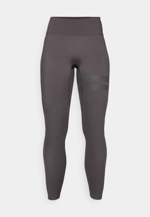 Magas derekú, testhez simuló leggings sötétszürke anyagból. Bal combján texturált csíkos díszítéssel. Sima, rugalmas anyag.