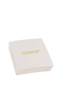 Vit smyckeskrin med guldtexten "amor" centrerad på locket, avbildat stängt mot en vit bakgrund.