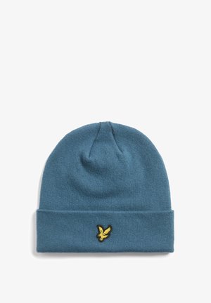 Knitted beanie in a soft blue color with a folded cuff. Features a small gold embroidered logo of a bird on the front.