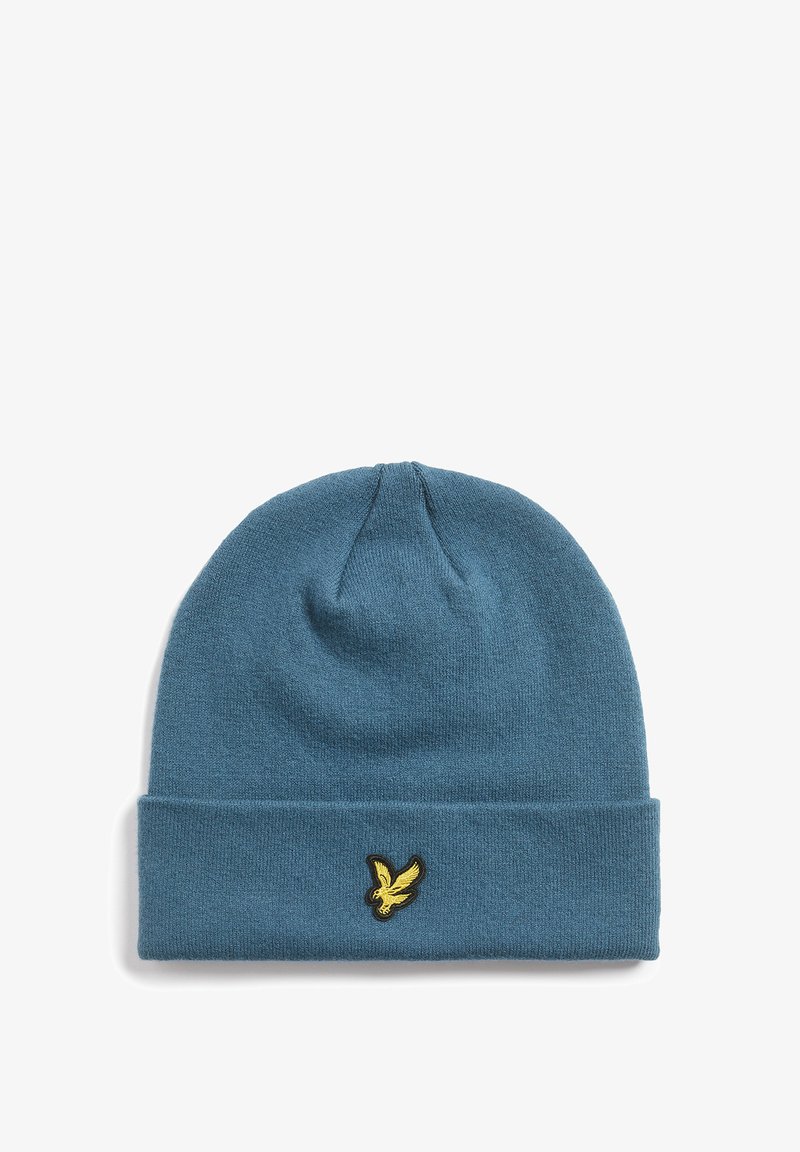 Knitted beanie in a soft blue color with a folded cuff. Features a small gold embroidered logo of a bird on the front.