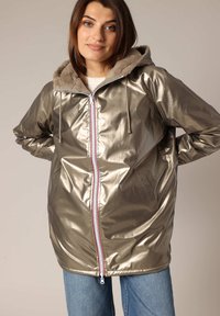 Veste à capuche argent métallique avec une doublure en fausse fourrure, dotée d'une fermeture éclair à l'avant avec des accents rouges et blancs et des poches latérales.