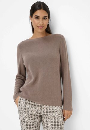 Brown ribbed sweater with a wide neckline and long sleeves, paired with patterned trousers featuring geometric designs in beige and brown tones.
