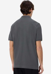Polo a maniche corte grigio realizzato in un morbido misto cotone, con colletto classico e vestibilità regolare, senza loghi o fantasie visibili.