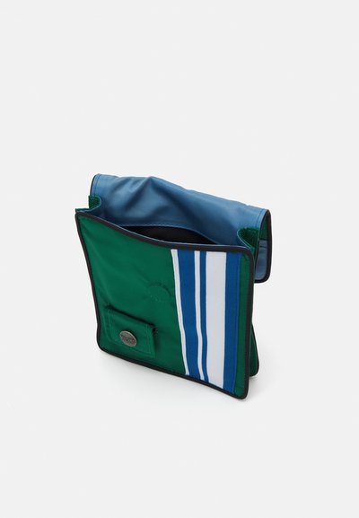 Pungă din țesătură verde și albastră cu trei dungi albe orizontale, deschidere în partea de sus și bordură neagră. Prezintă un buzunar frontal cu închidere prin apăsare.