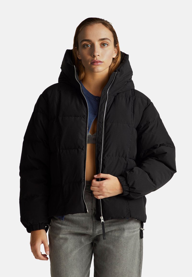 Czarna kurtka puchowa z zapinanym przodem, kapturem i elastycznymi mankietami; ma pikowany wzór i pudełkowy krój.