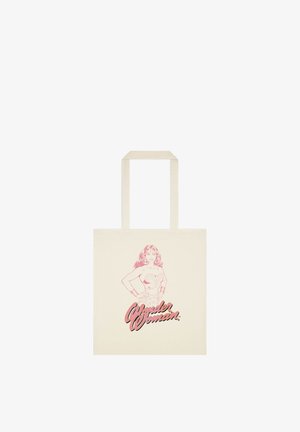 Kremowa torba typu tote z różowym szkicem Wonder Woman stojącej z rękami na biodrach i napisem „Wonder Woman" poniżej.