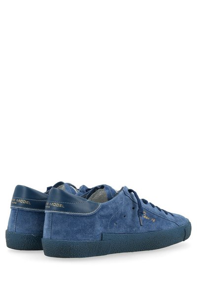 Sneaker blu scamosciate con accenti blu navy, punta rotonda, lacci discreti, marchio dorato sul tallone, suola in gomma testurizzata. Fodera interna liscia.