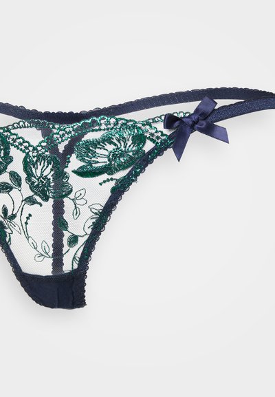 Tumes sinine pitsist stringbiki, millel on rohelised lillemustrid, lainelised ääred ja satiinist kaunistus. Omab läbipaistvat sõrestikmaterjali ja reguleeritavaid rihmasid.