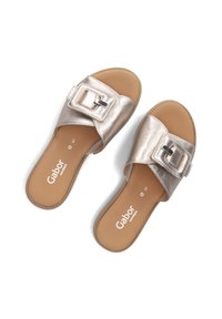 Metalen gouden slide-sandalen met een brede band en een vierkante gesp. Zachte binnenvoering en platte zool voor comfort. Merklogo zichtbaar op de voetbed.