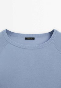 Pull en maille bleu clair avec col rond, col côtelé et manches raglan, présenté à plat sur un fond blanc.