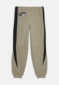 Šviesiai rudos Nike Air sportinės kelnės su juodais šoniniais intarpais, elastinga juosmens juosta, šoninėmis kišenėmis ir raibomis rankogaliais.