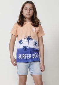 Tričko s krátkym rukávom v gradientnej oranžovo-modrej farbe, s grafickým motívom palmy a bielym textom "SURFER SOUL". Voľný strih, bavlnený materiál.