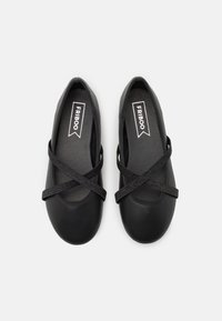 Czarne baleriny o gładkim, matowym wykończeniu, z krzyżującą się elastyczną tasiemką na podbiciu oraz okrągłym noskiem.