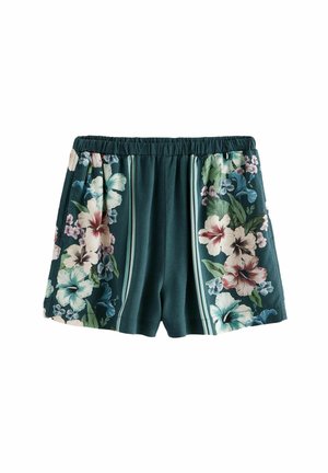 Shorts à imprimé floral en tissu teal foncé avec une taille élastique. Présente de grands motifs d'hibiscus et de plus petits motifs floraux sur les côtés.
