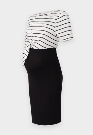 Jupe noire mi-longue associée à un haut à manches courtes à rayures blanches avec un détail de nœud noué à la taille, fabriqué en tissu doux.