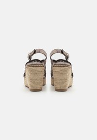 Sandalias de cuña con tacón de cuerda trenzada, tiras de tela metálica, hebilla ajustable en el tobillo y diseño de espalda abierta.